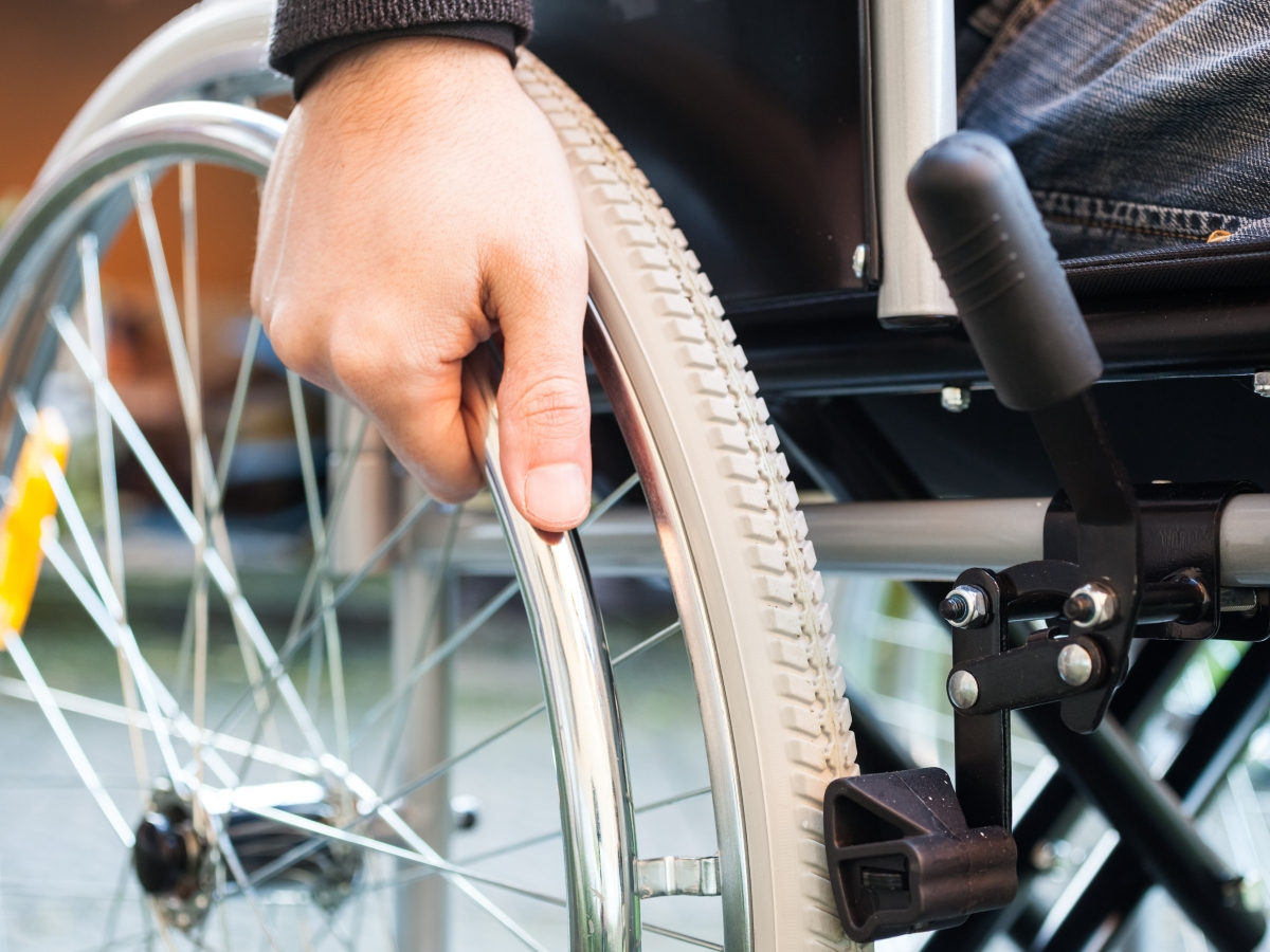 BKK VBU Pflegeportal ambulante Pflegeleistungen: Hand eines Rollstuhlfaherers am Reifen