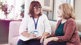 Beratungsgespr&auml;ch zwischen zwei Frauen auf dem Sofa