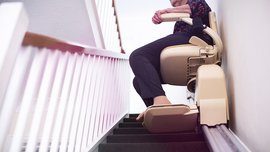 Eine Frau sitzt auf einem Treppenlift