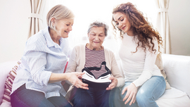 BKK VBU Pflegeportal ambulante Pflegeleistungen: &auml;ltere Frau auf einem Sofa sitzend umgeben von ihrer Tochter und Enkeltochter